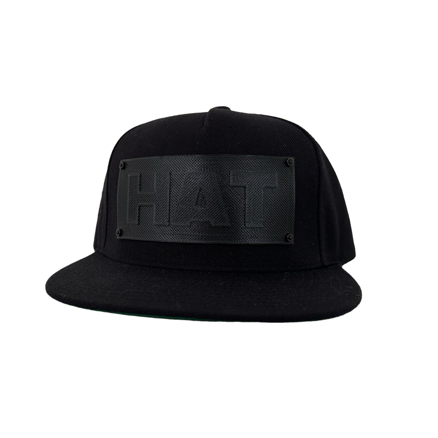 A black snapback baseball hat with a black logo panel that says"HAT".