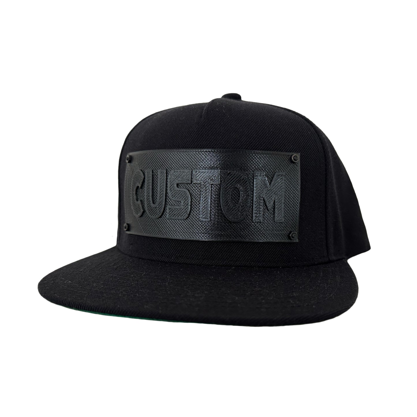 A black snapback baseball hat with a black logo panel that says"CUSTOM".