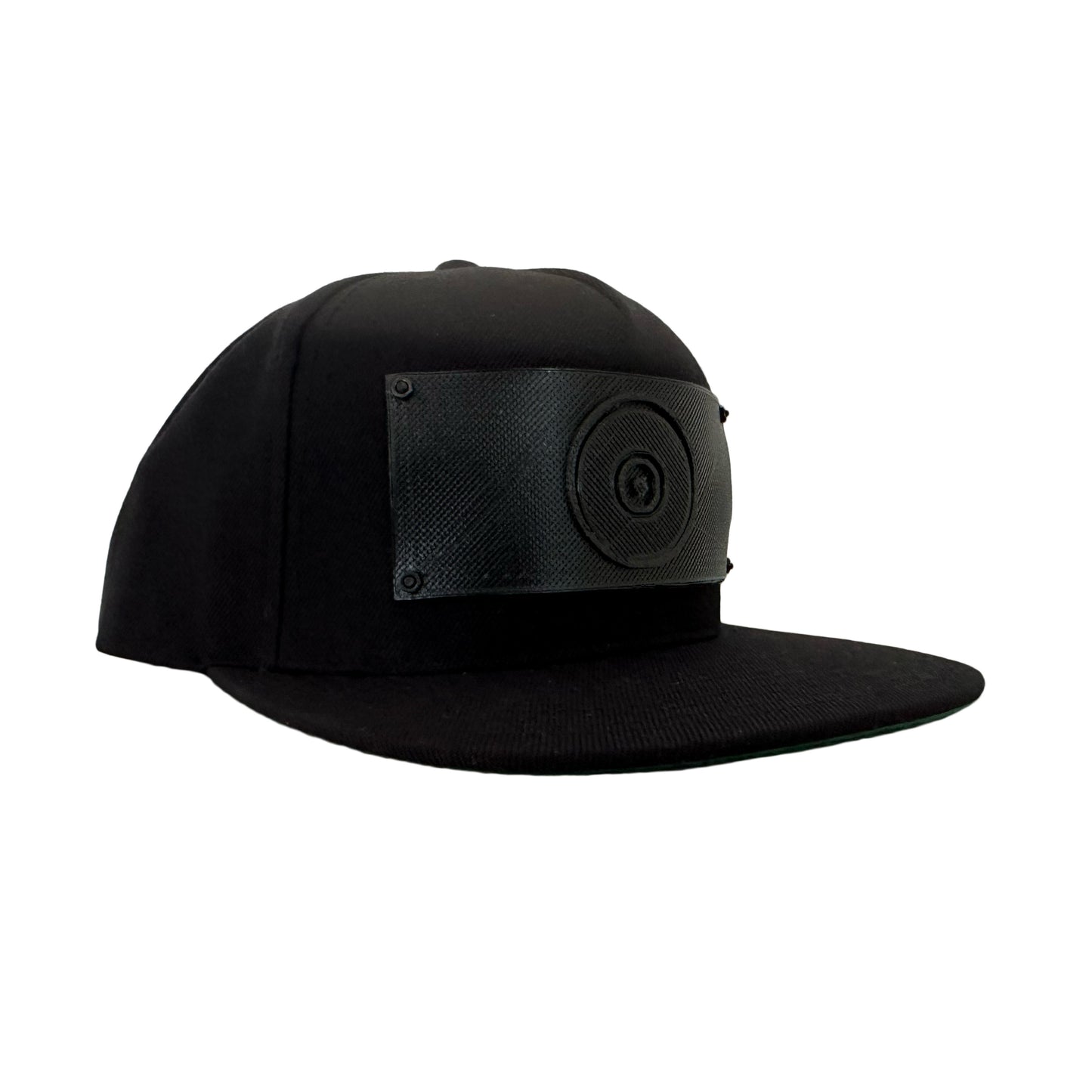 A black snapback baseball hat with a 3D printed black logo panel with an evil eye symbol on it.