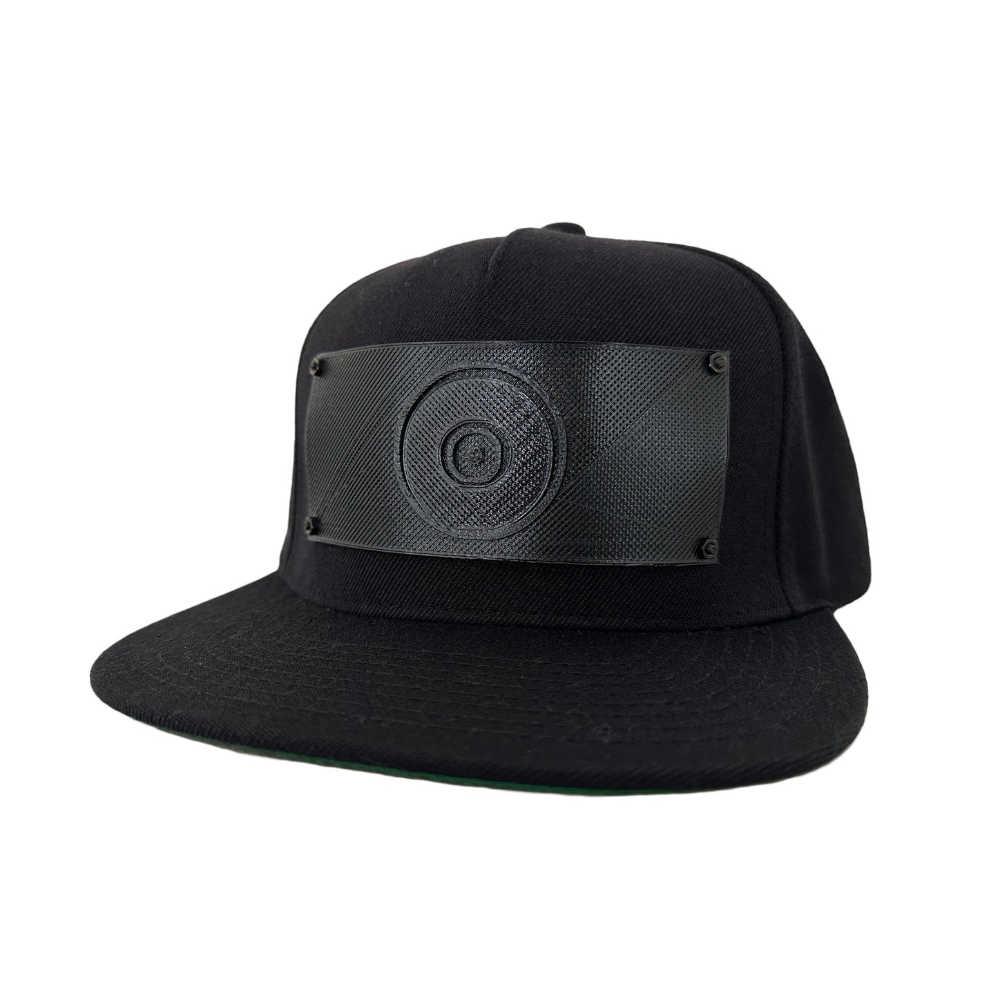 A black snapback baseball hat with a 3D printed black logo panel with an evil eye symbol on it.