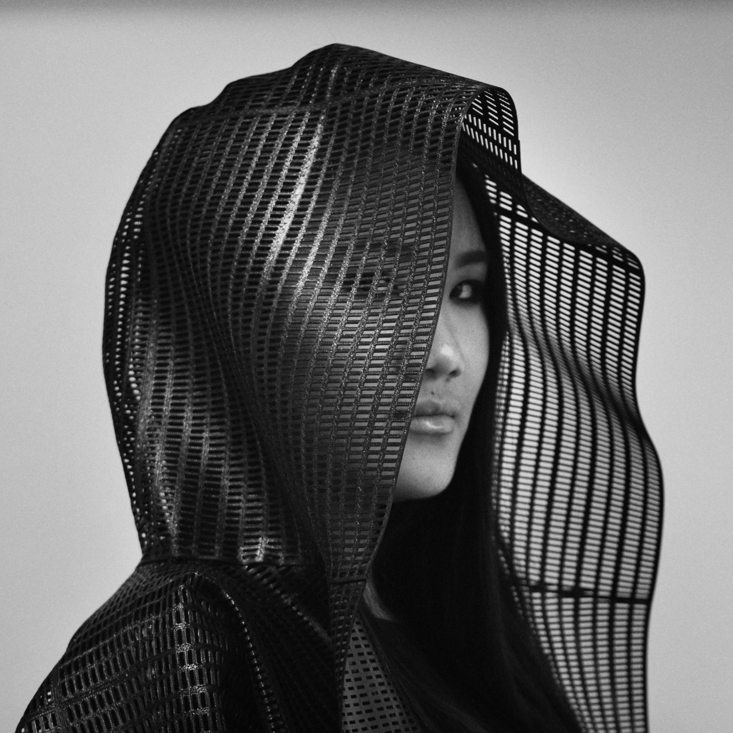 headshot of a woman wearing  a hooded 3D printed coat
